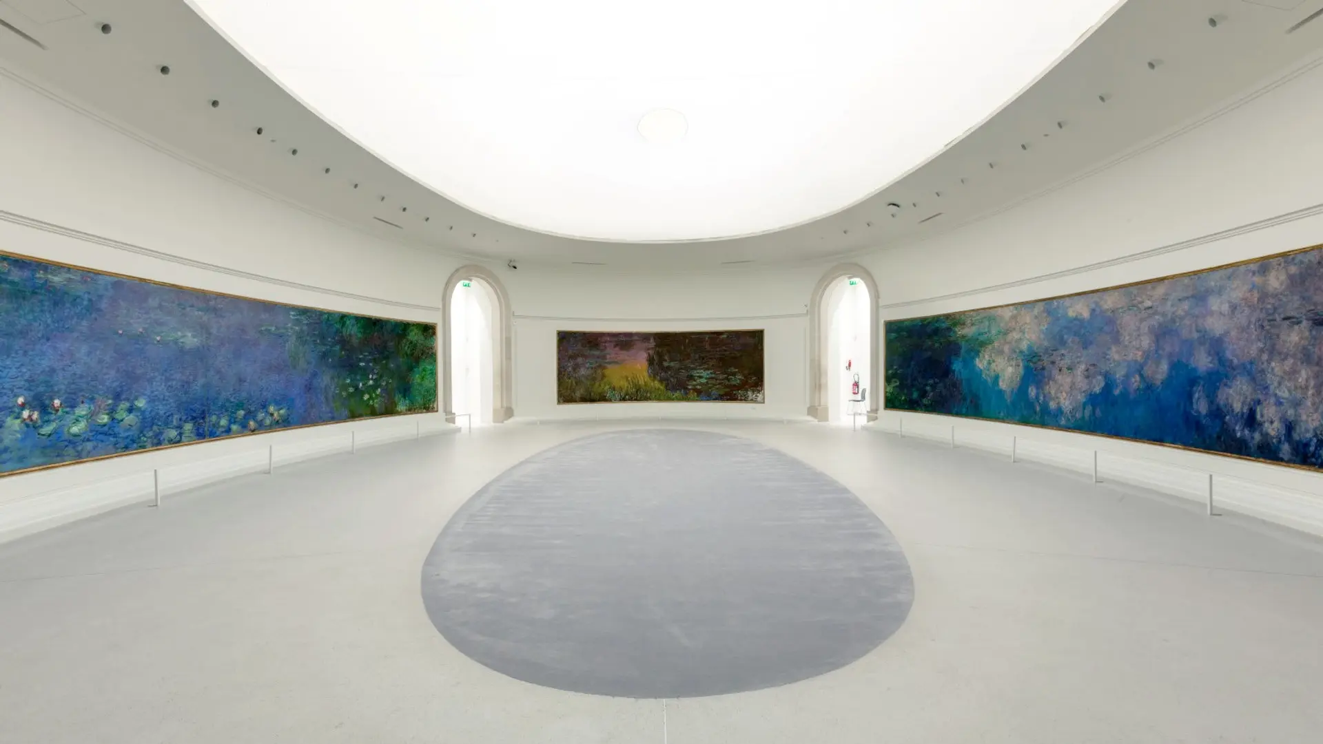 Inside Musee De L'Orangerie with white roof and floor and blue walls.