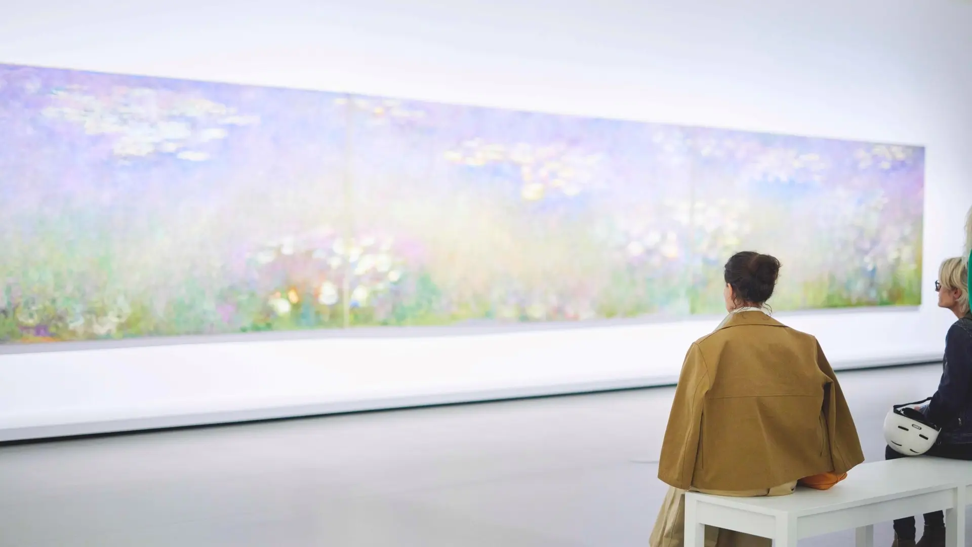 Two women looking at a wall inside Louis Vuitton Foundation.